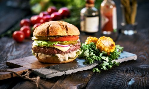 Homemade delicious hamburger on aged wooden table