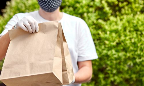 Courierin white hold go box food, delivery service, Takeaway restaurants food delivery to home door. Stay at home safe lives from coronavirus COVID-19 outbreak. Contactless delivery service under quarantine.